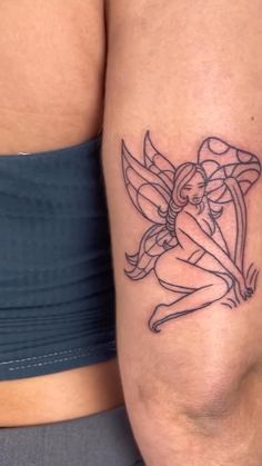 a woman's thigh with a tattoo design on her leg and an angel sitting on top of it