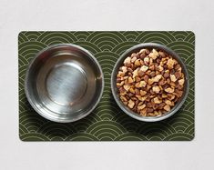 two metal bowls with food in them on a blue mat