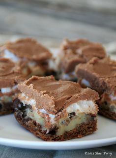 several pieces of dessert on a plate with chocolate and marshmallows in the middle