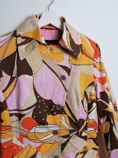 Gorgeous 90's cotton trench coat, beautiful 60's style floral print in pink, brown and yellow. Brand Damo Orange Label. Excellent vintage condition. Would fit size S-M. Size tag reads D 38/ UK 12/ F 42. Please read the measurements carefully and compare to one of your own garments to avoid any disappointment regarding the fit. Measurements of the item, laying flat: - shoulders: 40 cm; - chest (pit to pit): 50 cm; - waist: 42 cm; - length (nape to bottom): 88 cm; - sleeve (pit to cuff): 46 cm. Al Retro Spring Outerwear With Lapel Collar, Retro Lapel Collar Outerwear For Spring, Retro Outerwear With Lapel Collar For Spring, Retro Spring Outerwear With Graphic Print, Retro Graphic Print Outerwear For Spring, Vintage Summer Workwear Outerwear, Retro Multicolor Summer Outerwear, Fitted Vintage Outerwear With Graphic Print, Retro Spring Workwear Outerwear