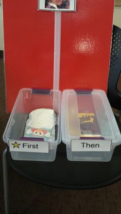 there are two plastic containers with food in them on the desk next to a red wall