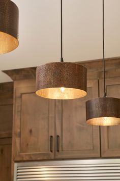 three lights hanging from the ceiling in a kitchen