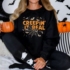 "🦇 Embrace the spooky season with our \"Creepin' It Real\" unisex crew neck sweatshirt! 🕷️ This Halloween-inspired sweatshirt is the perfect way to showcase your love for all things eerie and mysterious. With bats and spider webs surrounding the distressed-style text, you'll be ready to keep it real in style this October. 🎃 Sweatshirt Details: -Material: A cozy blend of 50% cotton and 50% polyester for maximum comfort -Medium-heavy fabric (8.0 oz/yd² or 271.25 g/m²) ensures warmth and durabil Halloween Crew Neck Sweater, Black Halloween Sweatshirt With Crew Neck, Black Crew Neck Halloween Sweatshirt, Black Crew Neck Sweatshirt For Halloween, Spooky Halloween Crew Neck Sweater, Halloween Crew Neck Sweatshirt For Loungewear, Spooky Letter Print Sweatshirt For Winter, Spooky Crew Neck Sweatshirt For Fall, Creepin It Real