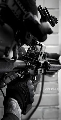 a black and white photo of a person holding a camera on a motorcycle handlebar