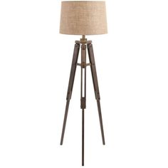 the floor lamp is made out of wood and has a beige shade on top of it