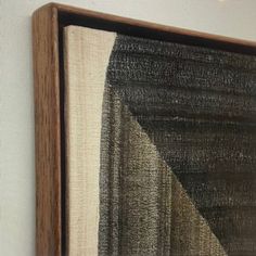 a painting hanging on the wall next to a white wall with a black and brown design