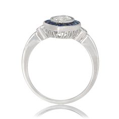 This is an antique Sapphire-Halo ring featuring a very rare marquise 1.01 Carat diamond in the center. The sapphire halo around the diamond consists of natural calibre French-cut sapphires with a total carat weight of .50. The diamond is GIA certified. ✦DIAMOND SPECIFICATIONS: Center Diamond Weight: 1.01 Carats Center Diamond Clarity: VS2 Clarity Center Diamond Color: H Color ✦ ENGAGEMENT RING SPECIFICATIONS: Ring Material: Handcrafted Platinum Total Gram Weight: 5.0g Ring Material: Platinum ✦ W Gia Certified Platinum Rings In White Gold, Classic Gia Certified White Gold Cluster Ring, Round Platinum Sapphire Ring With Vvs Clarity, Platinum Sapphire Ring With Vvs Clarity, Vvs Clarity Sapphire Ring In Platinum, Classic Sapphire Diamond Ring Gia Certified, Gia Certified Platinum Sapphire Ring, Round Cut, Classic Gia Certified Sapphire Platinum Ring, Classic Gia Certified Platinum Sapphire Ring