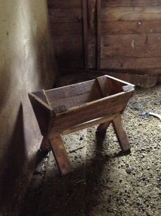 an old wooden wheelbarrow sitting in the corner of a room next to a wall