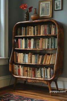 a bookshelf filled with lots of books on top of a hard wood floor