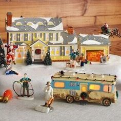 there are many toy houses and people in the snow