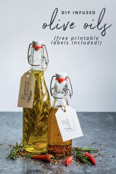 two bottles filled with olive oil sitting on top of a table