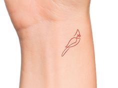 a small red bird tattoo on the wrist