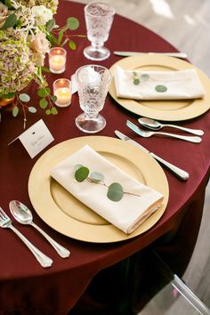 the table is set with silverware and place settings