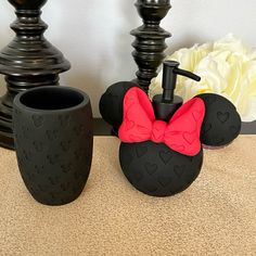 mickey mouse soap dispenser and toothbrush holder with pink bow on it