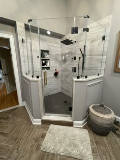 a walk in shower sitting inside of a bathroom next to a rug on the floor