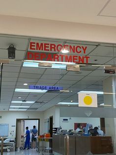 an emergency department entrance with people standing in the doorway and on the other side of the door