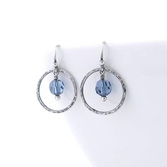 Dainty Dot Earrings - Some days you just want a simple pair of everyday earrings with just a tiny bit of color. These dainty circle earrings are perfect, lightweight earrings and consist of Sterling Silver 0.875 inch hammered circles suspended from Sterling Silver balled earwires.  Elegantly suspended within the silver circle is a tiny 6mm Denim Blue crystal bead providing just a hint of color. The total length of the earrings from the top of the earwires to the bottoms of the circles is a petit Blue Metal Earrings For Everyday Wear, Everyday Blue Metal Earrings, Everyday Blue Circular Earrings, Everyday Blue Circle Earrings, Everyday Round Crystal Earrings With Ear Wire, Nickel-free Round Crystal Earrings For Everyday, Dangle Silver Earrings, Silver Circle Earrings, Dot Earrings