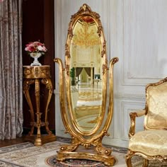 an ornately decorated living room with gold furniture and mirrors on the wall, along with a floral centerpiece