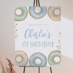 a welcome sign with donuts and sprinkles in blue, gold and white