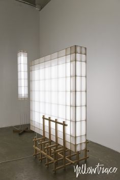 an empty room with several wooden posts and windows on the wall, in front of a white backdrop