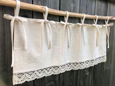 a white curtain hanging on the side of a wooden fence