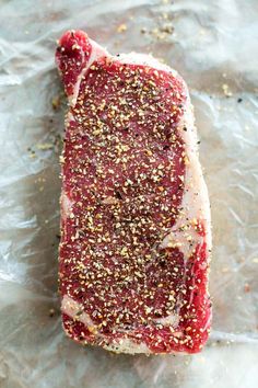 a piece of raw meat with seasoning on it