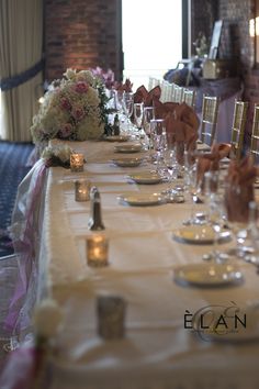 a long table is set with wine glasses and candles