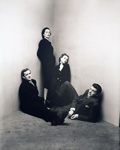 an old black and white photo of three people sitting on the floor in front of a wall