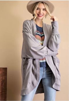 This timeless frost gray cocoon cardigan is the perfect layering piece for any season. We are loving the lightweight soft sweatshirt style material for chilly summer nights. We also adore the curved, vintage hem and double pockets for a great accent. There are so many ways to style this cardigan pair it with a bodysuit and shorts or wear over a tee. Any way you style it will surely look cute! Oversized fit. Casual Fall Cardigan With Soft Texture, Soft Casual Outerwear For Loungewear, Casual Soft Cardigan For Fall, Comfy Fall Outerwear In Solid Color, Comfy Solid Color Fall Outerwear, Casual Soft Outerwear For Loungewear, Casual Soft Texture Fall Cardigan, Comfy Solid Outerwear For Fall, Gray Fall Sweater With Pockets