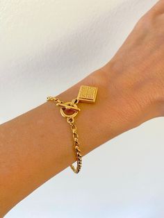 Vintage Givenchy toggle charm bracelet.  One side of the charm is the signature Givenchy 4Gs logo and the other side has 4 colorful stones in a square (dark red, golden, sapphire blue, green). In beautiful condition. The bracelet is a generous 7.5" long. It can be easily shortened by removing links of the chain. If you would like it delivered already shortened to your desired length, please send a message with your order. A perfect gift to yourself, or a loved one. A true treasure. Please note: Gold-tone Metal Jewelry With Logo Charm, Gold-tone Chain Bracelet With Logo Charm As Gift, Gold-tone Chain Link Jewelry With Logo Charm, Yellow Gold Metal Chain Bracelet With Logo Charm, Gold-tone Bracelet With Logo Charm As Gift, Adjustable Chain Bracelet With Toggle Clasp As Gift, Metal Bracelet With Logo Charm, Gold Plated Bracelet With Toggle Clasp, Luxury Charm Bracelet With Logo Charm As Gift