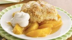 a white plate topped with peach cobbler and whipped cream