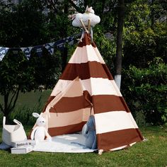 a brown and white striped teepee sitting in the grass