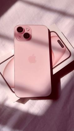 two pink iphones sitting on top of each other