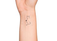 a hand with a cat tattoo on it's left wrist and the outline of a cat