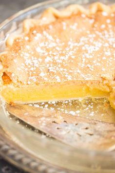 a close up of a pie on a plate with powdered sugar over the crust