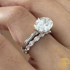 a close up of a person's hand with a diamond ring on their finger