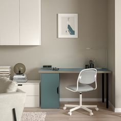 a white desk with a laptop on top of it next to a chair and table