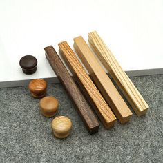 wooden pegs and knobs on the floor next to a white board with words