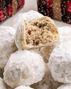 a pile of snowball cookies sitting on top of a white plate covered in powdered sugar