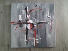 an abstract painting with red and black accents on a wood flooring area that looks like it has been painted