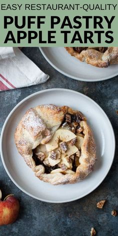 two white plates topped with apple pies on top of a gray table next to an apple