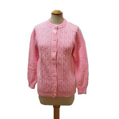 "Lovely pink sweater from the 70s. This long sleeved cable knit cardigan closes with 7 matching spun yarn buttons. Collar, cuffs, and bottom are ribbed and the sweater is midweight acrylic wool. Unworn condition. The only issue is a small spot on the back of the right sleeve at the elbow. Please note the color is a bright medium pink and not as light as it appears and the color is even throughout. Size label 36 or modern small - Reitman's - Made in Taiwan - 100% acrylic wool  36\" bust - 26\" le Classic Pink Knit Sweater, Classic Pink Cable Knit Sweater, Vintage Pink Knit Cardigan, Classic Pink Winter Cardigan, Vintage Pink Cardigan With Buttons, Vintage Pink Winter Cardigan, Pink Vintage Winter Cardigan, Leather Outerwear, Vintage Clothes Women