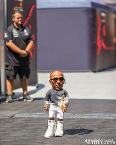 a little boy with sunglasses and knee pads standing in front of a man on the street