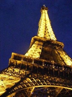 the eiffel tower is lit up at night