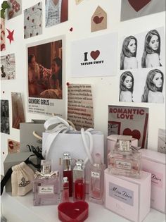 several perfume bottles are sitting on a table in front of wall with pictures and photos