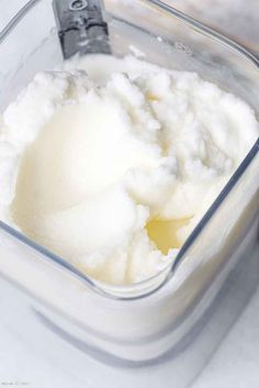 a food processor with mashed potatoes in it and a spoon next to the container