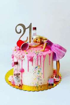 a birthday cake with a barbie doll laying on top of it and pink icing