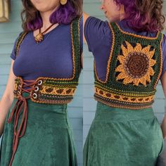 two women dressed in green skirts and purple tops with sunflowers on their shoulders