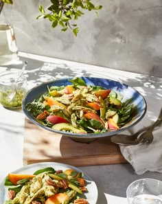 two plates of food on a table with glasses and utensils in the background