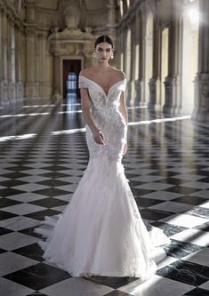 a woman in a white wedding dress standing on a black and white checkered floor